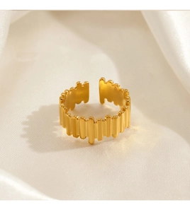 Detail of 18K gold plated stainless steel wave ring on white silk fabric background