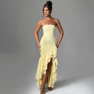 Detail of light yellow strapless dress featuring ruffled asymmetric hem and slim fit