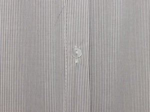 Close-up of grey striped cotton shirt fabric with a translucent round button detail