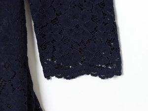 Detailed view of dark blue lace cuffs with intricate scalloped edges and hollow embroidery