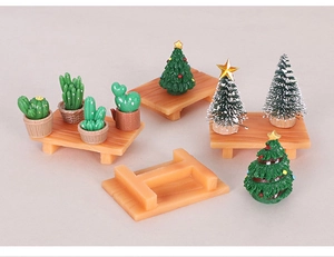 Close-up of miniature Christmas trees and cactus figurines for festive DIY desk decor