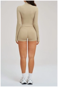 Back view of a khaki women's two-piece sports set with slim-fit zip-up jacket and biker shorts