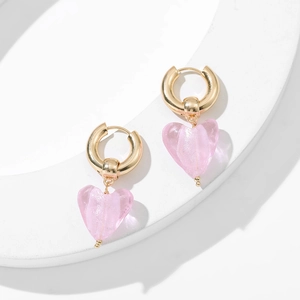 Boucles d'oreilles créoles dorées vintage avec pendentifs cœur rose sur socle blanc