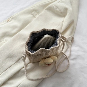 Mini borsa a secchiello in paglia crema con ciondolo floreale e chiusura a coulisse