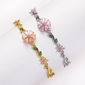 Detailed close-up of pink cherry blossom bracelets in gold and silver with zircon petals