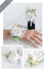 Detail of white artificial rose wrist corsage and boutonniere set with satin ribbons