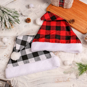 Classic red and white plaid Christmas hats with plush trim on snowy festive background
