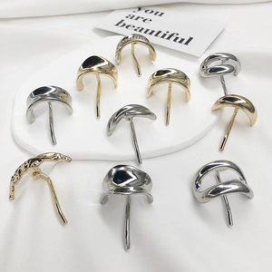 Minimalist gold and silver metal hair clips displayed on elegant white silk background