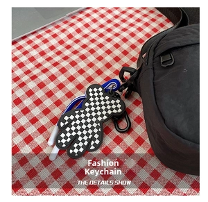 Detailed close-up of a checkered bear charm with blue woven rope and metal hook