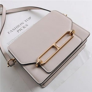 Dettaglio di una borsa in pelle bianco crema minimalista con fibbia in metallo dorato