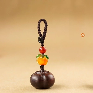Macro detail of wooden persimmon pendant with brown woven cord and elegant lobster clasp