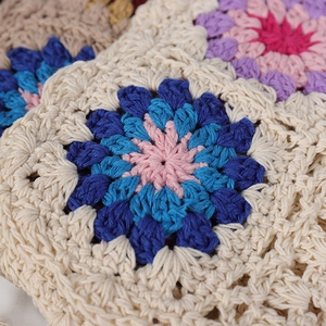 Close-up of handmade crochet granny square details with floral patterns and soft cotton yarn