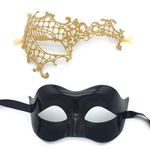 Detail of gold lace hollow mask and black sleek eyemask with silk ribbons for Masquerade