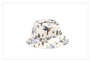 Close-up detail of the elegant bird and floral print on a faux silk bucket hat
