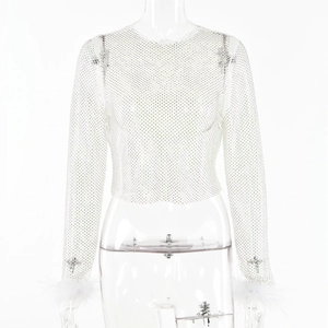 Gros plan sur le haut en maille strass blanc avec bordure en plumes aux poignets