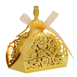 Detail of laser-cut gold wedding favor box in princess dress shape with ribbon