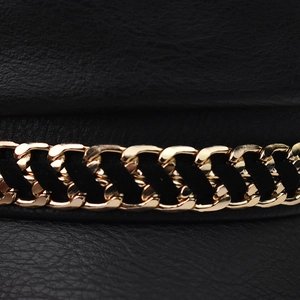 Detail of black faux leather beret featuring crocodile texture and golden chain trim