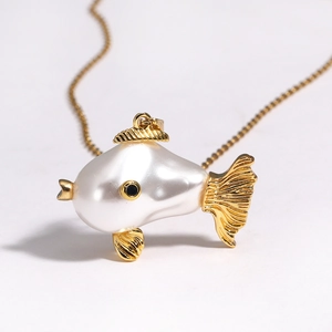 Detailed macro view of a cute fish necklace with baroque pearl and golden metal fins