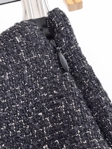 Close-up of black and white tweed fabric with invisible zipper detail for skirt set