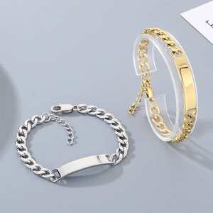 Close-up of gold and silver titanium steel Cuban chain bracelets with engravable plates