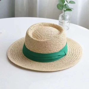 Detail of natural straw texture and green ribbon on a stylish sun hat for summer