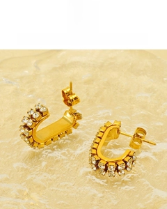 Macro detail of 18K gold plated U-shaped earrings with double-row cubic zirconia stones