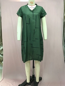 Detail of green V-neck short sleeve dress with black abstract geometric line patterns