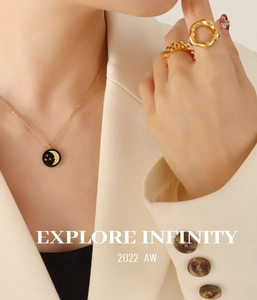 Close-up of golden star and moon pendant necklace with geometric rings on a model
