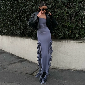 Detail of ruffled hem and slim fit cut on a greyish-blue strapless maxi dress