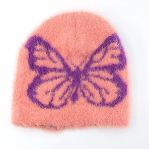 Close-up of pink fuzzy beanie featuring a large purple butterfly knit pattern