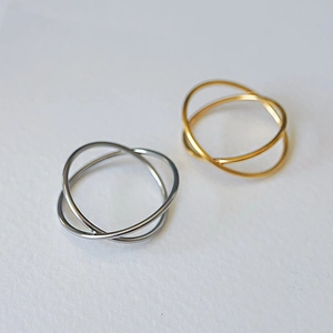 Detail view of interlocking gold and silver titanium steel rings on grey background