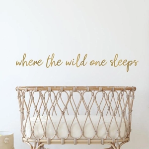 Natural rattan baby bassinet with where the wild one sleeps gold wall sticker decor