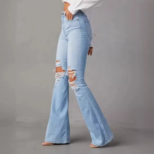 Jean flare taille haute bleu clair avec détails déchirés stylés et finition délavée