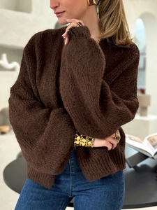 Close-up of thick dark brown knit cardigan with chunky gold jewelry accents