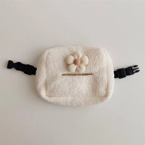 Dettaglio del porta fazzoletti in pile bianco con un fiore decorativo in velluto a coste