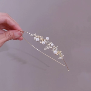 Detail of golden headband featuring sparkling zircon butterflies and elegant white pearls