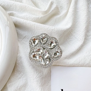 Detail shot of luxury rhinestone cat paw phone socket on textured white linen fabric