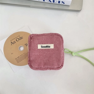Detail of pink corduroy pouch with soft texture and green zipper drawstring for storage