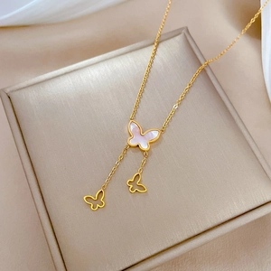 Detail of gold butterfly necklace with mother of pearl inlay on soft fabric