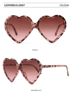 Detail view of heart-shaped sunglasses with leopard frame and brown gradient lenses