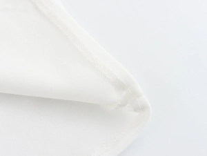 Detail shot of the precise double-needle stitching on the white cotton camisole top