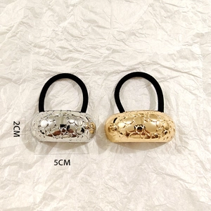 Detail view of silver and gold textured metal hair ties with 5cm length measurements