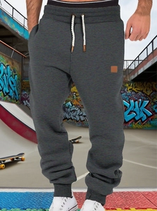 Close-up of men's dark grey jogger pants featuring drawstring waist and elastic cuffs