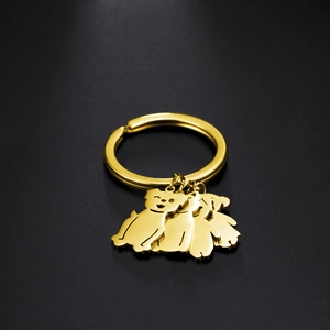 Golden stainless steel keychain featuring three cute puppy charms on a black background