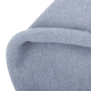 Macro shot of baby blue knitted fabric showing detailed stitching and soft wool texture