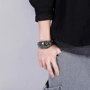 Détail d'un large bracelet tête de mort argenté vintage au poignet d'un mannequin homme