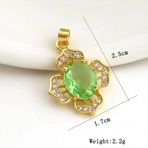Macro detail of gold flower pendant with green gemstone and white zirconias, 2.5cm size