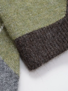 Detailed macro view of multicolor mohair knitwear showing fluffy texture and ribbed edge