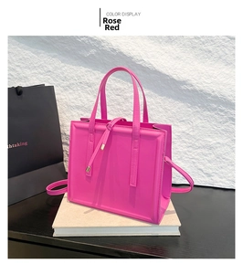 Dettaglio della borsa strutturata rosso rosa con cuciture verticali e tracolla