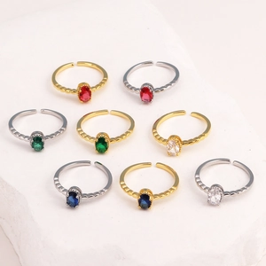 Detail view of adjustable rings with colorful oval stones in gold and silver finishes